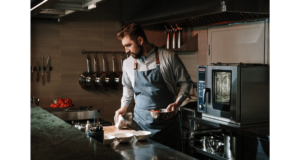 Man in a kitchen preparing food for the oven