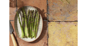 a plate of asparagus and knife on table