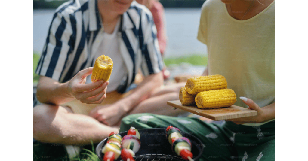 putting barbeque maize on grill