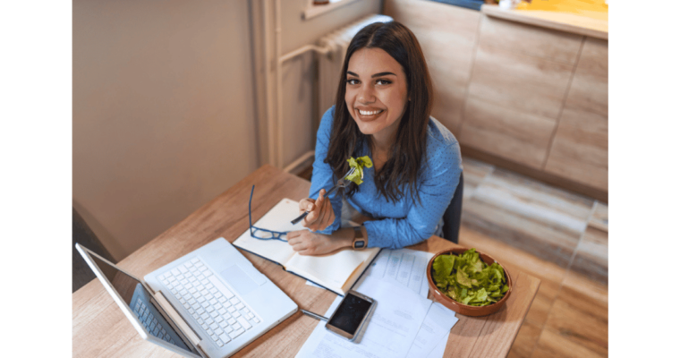 happy young woman enjoying a healthy salad at work eating on a budget