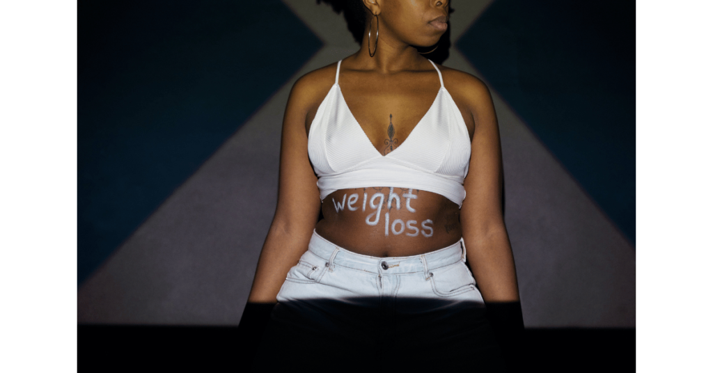 young woman with weight loss written on her stomach