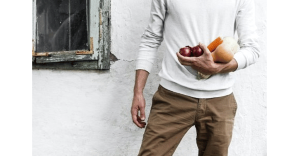 Man holding veggies and corn