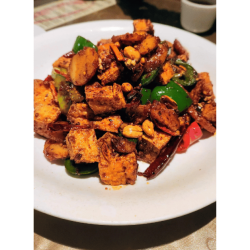 A white plate topped with tofu and peppers