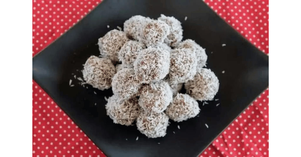 Coconut date balls on black plate