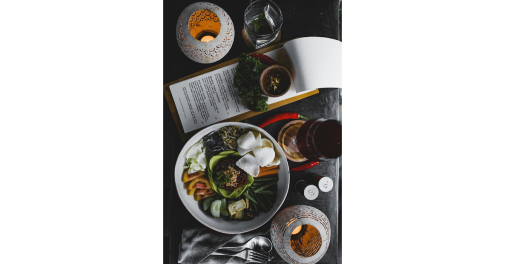 Serving table with vegan salad bowl and decorative lamps.