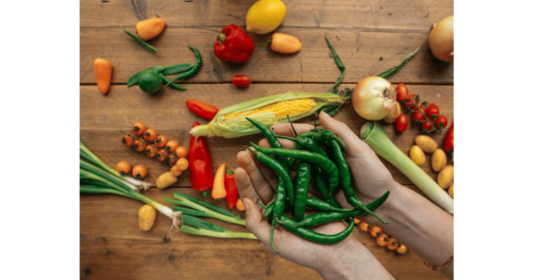 Green chilli pepper on a person's hands by Viktoria Slowikowska