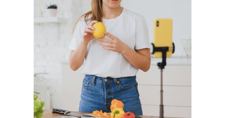 Woman food vlogger with smartphone filming food recipe