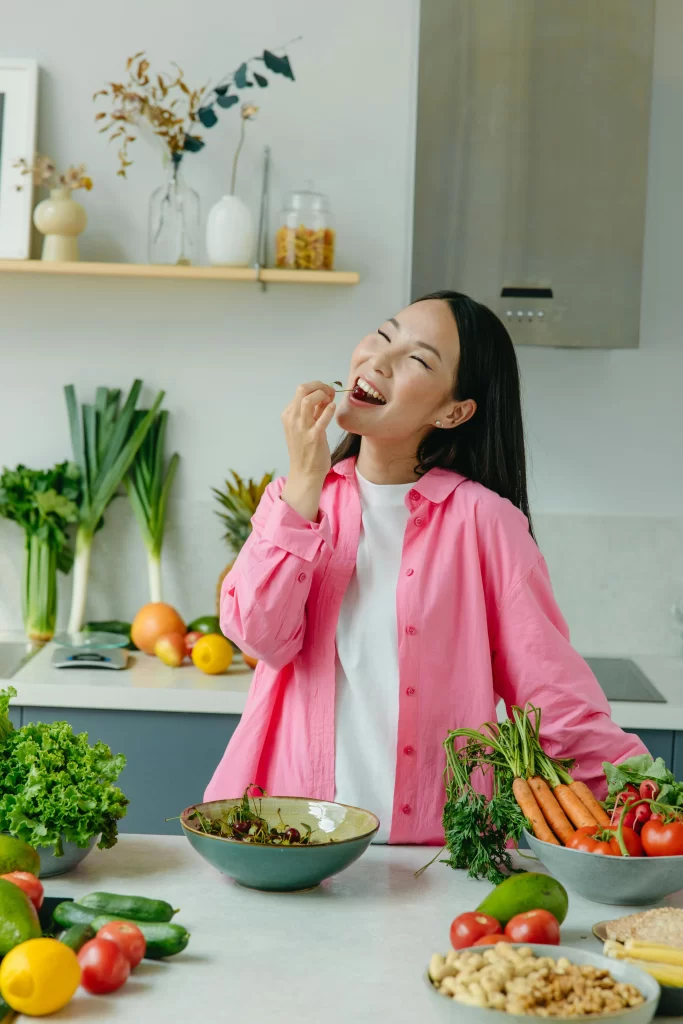 Lady with various plant-based foods and tasting prune.