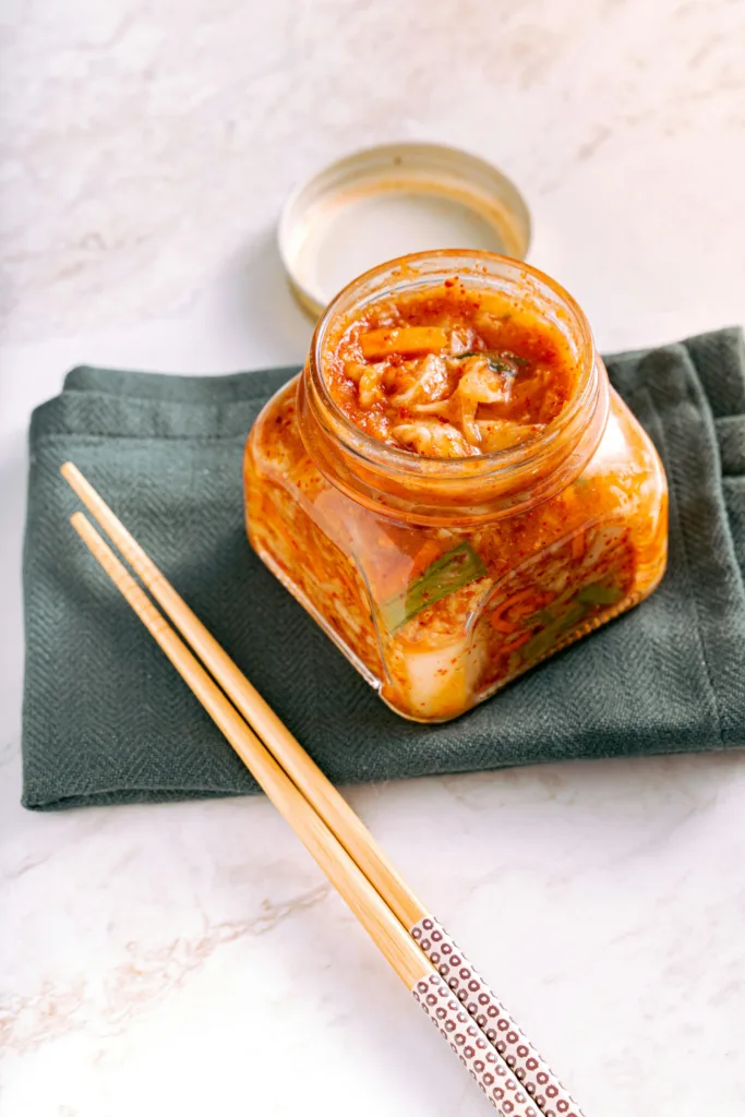 Kimchi on a clear glass jar for gut-brain connection.