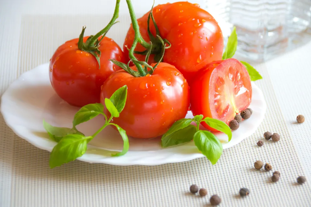 Tomatoes on top of a white ceramic plate, a south african vegan staple.